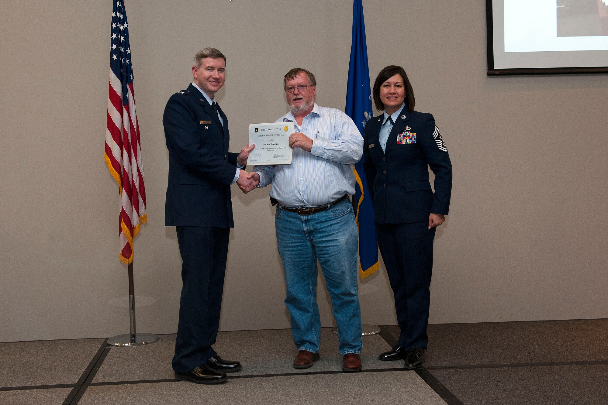 U.S. Air Force Col. Terry J. Hamrick, 17th Training Wing Vice Commander, and Chief Master Sgt. JoAnne S. Bass, 17th TRW Command Chief, present the Civilian Category II Non-Supervisory of the Quarter award to Norman Fountain, 17th Communications Squadron, during the wing quarterly awards ceremony at the Event Center on Goodfellow Air Force Base, Texas, Jan. 29, 2016. (U.S. Air Force photo by Airman 1st Class Caelynn Ferguson/Released)