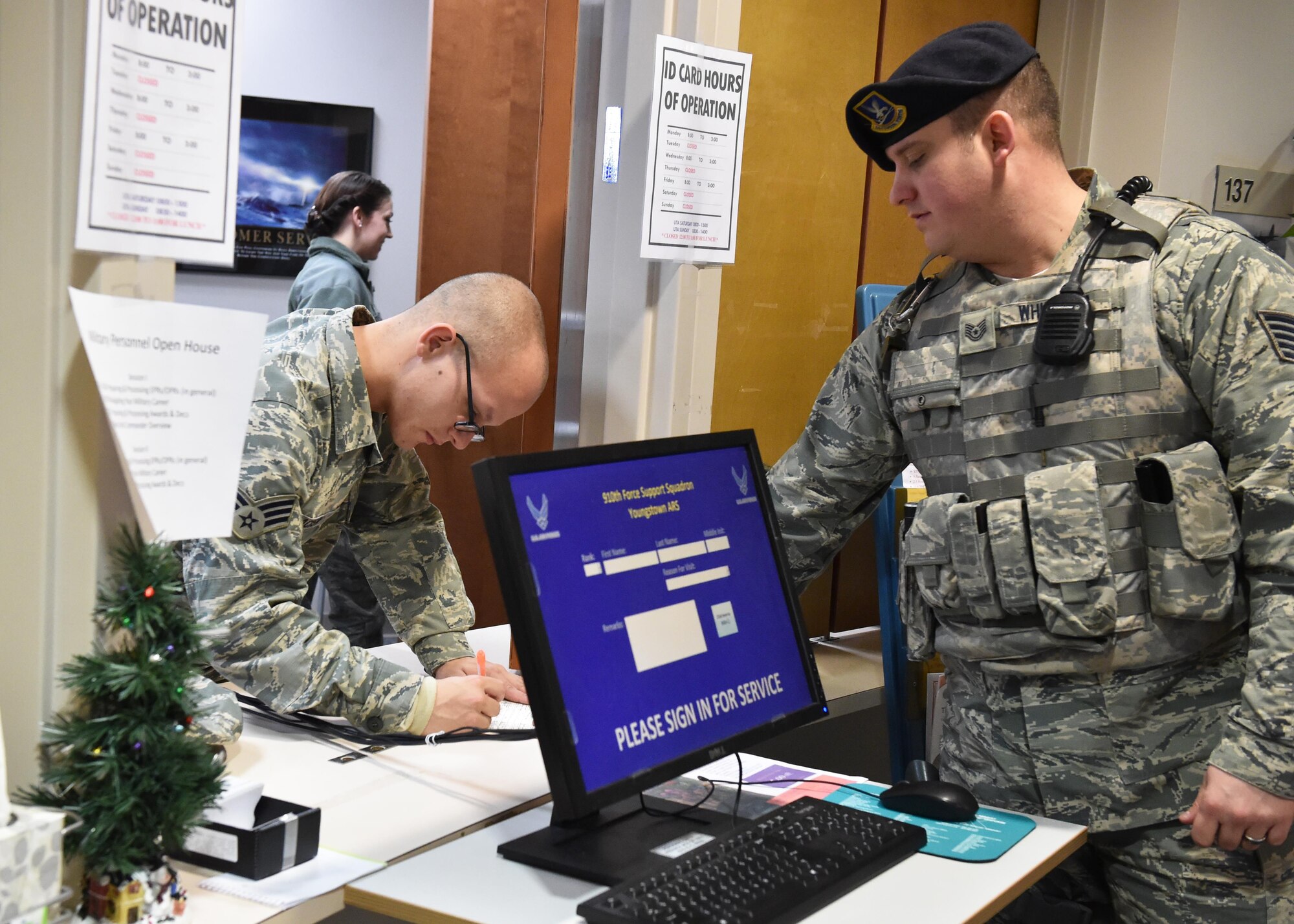Tech. Sgt. Wesley Whitaker, a 910th Security Forces Squadron fire team member, drops off a form to Senior Airman Nicholas Bacisin, 910th Air Wing, a customer support specialist with the Military Personnel Section, here Jan. 10, 2016. The Military Personnel Section processes forms, decorations and ID cards and performs other military processing functions. (U.S. Air Force photo/Staff Sgt. Rachel Kocin)