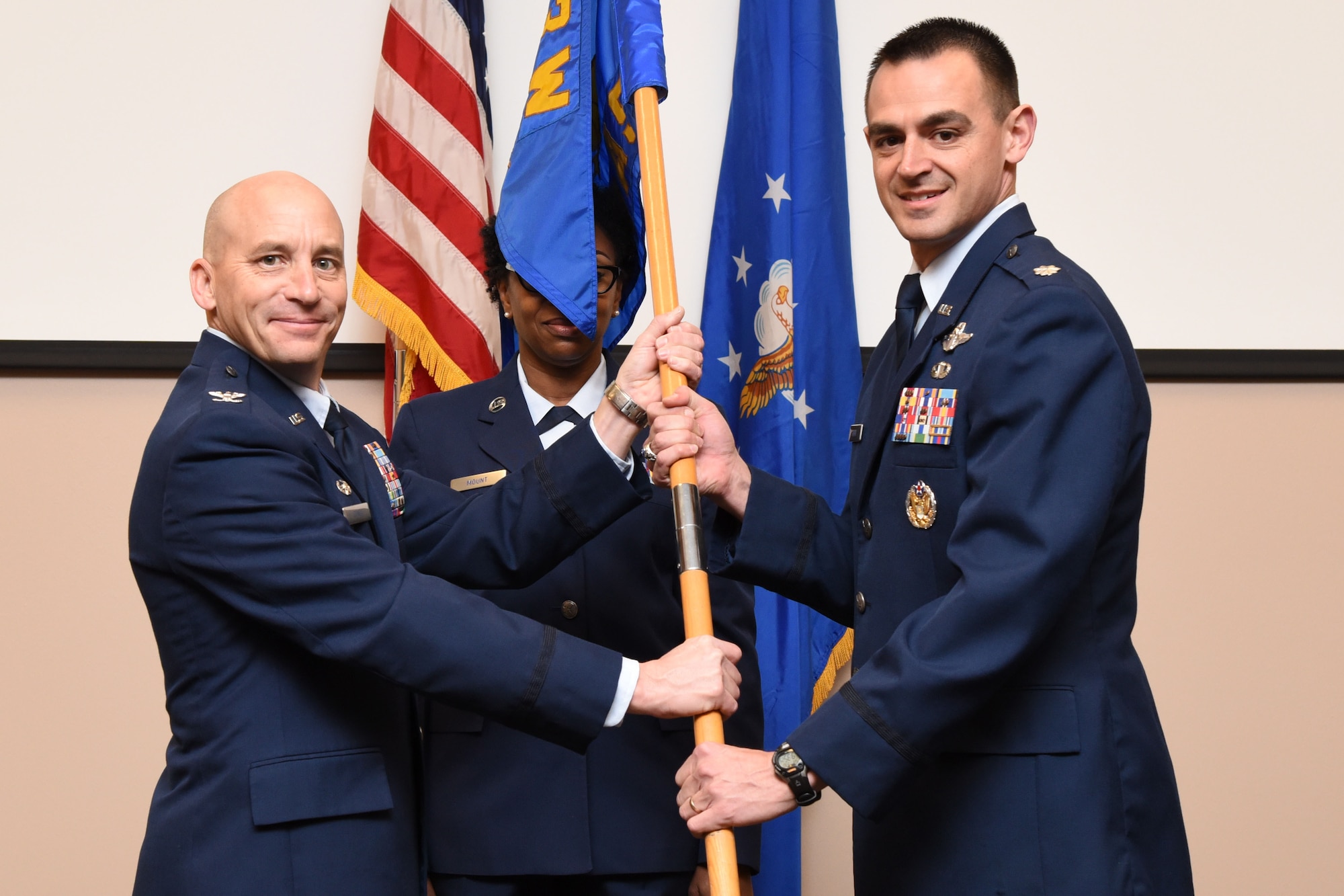 Col. David Condit, 403rd Operations Group commander, passes the 815th Airlift Squadron guide on to Lt. Col. Stuart Rubio, 815th AS commander, during a change of command ceremony January 30, 2016, at Keesler Air Force Base, Mississippi. Rubio took command of the 815th AS during the ceremony, which was held in the 815th AS building. (U.S. Air Force photo/Tech. Sgt. Ryan Labadens)