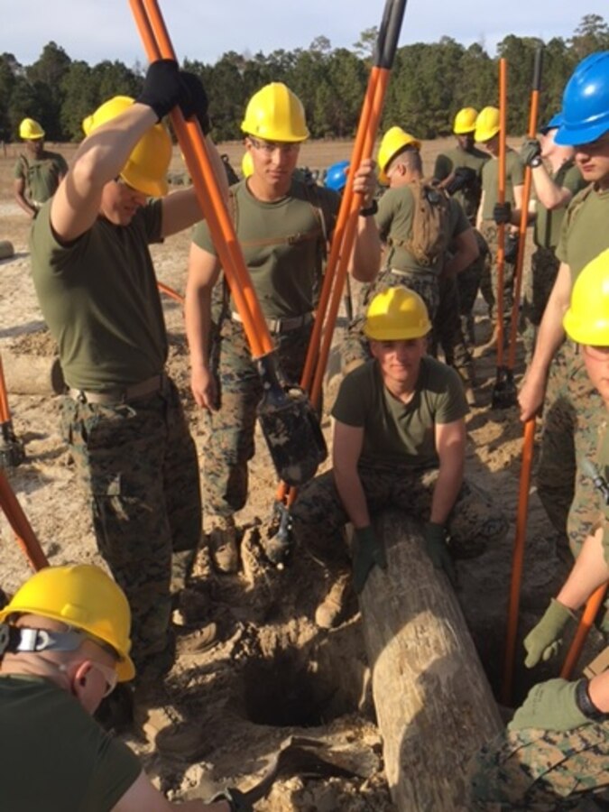 Students attached to the Basic Combat Engineer course 10-16 (BCE 10-16) at Marine Corps Engineer School, Camp Lejeune, N.C., emplace heavy logs to construct an obstacle as part of a practical application for the constructed obstacles class.

