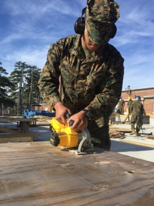 On January 26, 2016 Second Lieutenant Eric Johnson, a Marine attached to Combat Engineer Officer course 3-16 (CEO 3-16) at Marine Corps Engineer School Camp Lejeune, N.C.; uses a hand saw to create the correct measurements on boards needed to build a wall during a construction practical application.  
