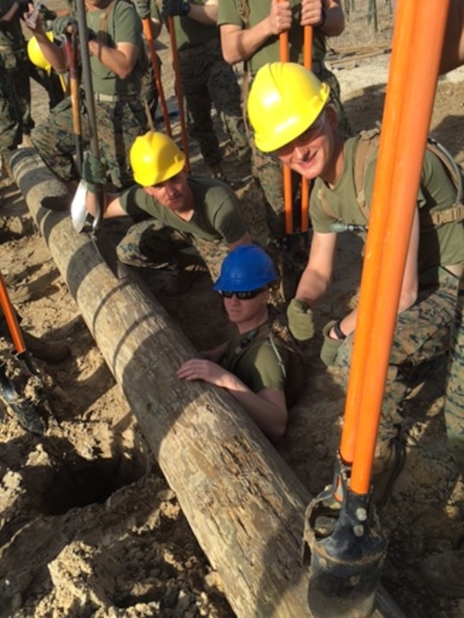 Students attached to the Basic Combat Engineer course 10-16 (BCE 10-16) at Marine Corps Engineer School, Camp Lejeune, N.C., emplace heavy logs to construct an obstacle as part of a practical application for the constructed obstacles class.
