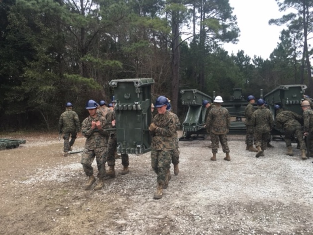 Marines attached to the Basic Combat Engineer course 10-16 (BCE 10-16) at Marine Corps Engineer School Camp Lejeune, N.C. participate in a Medium Girder Bridge practical application and manually transport pieces in order to assemble a Medium Girder Bridge.
