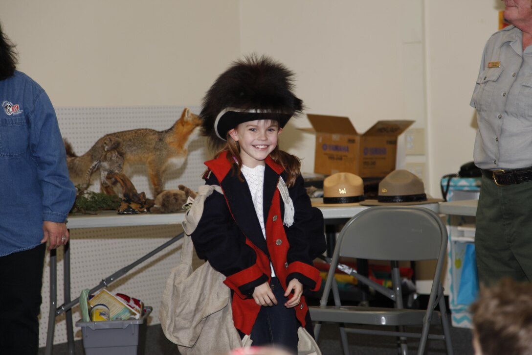 A student is all smiles as she tries on a Soldier's uniform from the Corps of Discovery era.