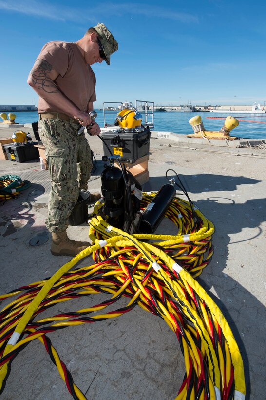 Navy Petty Officer 3rd Class Sean McHugh performs prechecks on diving equipment during underwater hydro tools training at Port Hueneme, Calif., Jan. 29, 2016. McHugh is a builder assigned to Underwater Construction Team 2. Navy photo by Chief Petty Officer Lowell Whitman