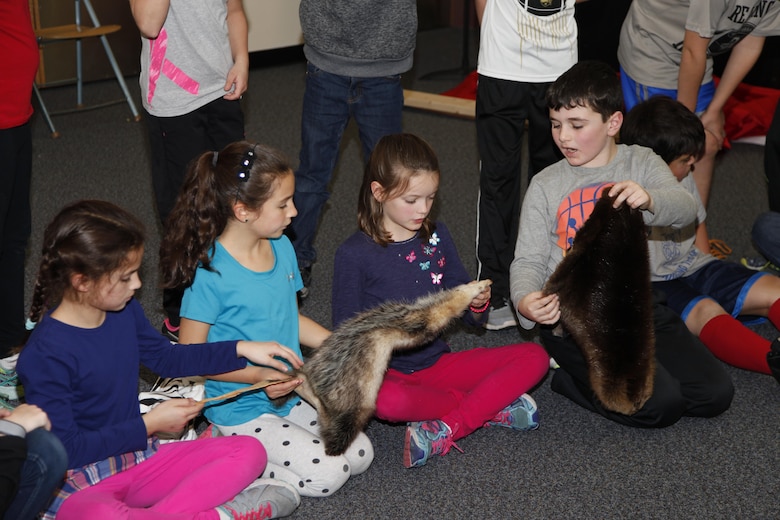Students touch real animal pelts during the presentation.