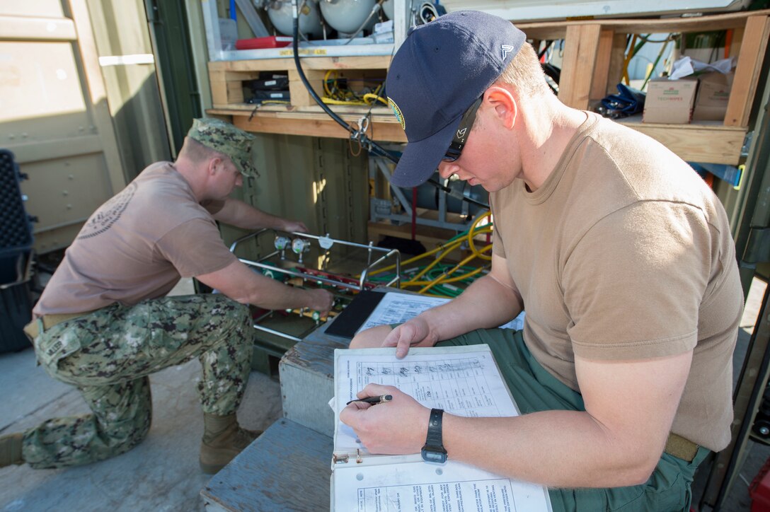 Navy Petty Officer 3rd Class Anderson Gardner, right, calls out prechecks on diving equipment to Navy Petty Officer 2nd Class David Miller during underwater hydro tools training at Port Hueneme, Calif., Jan. 29, 2016. Gardner is a construction mechanic and Miller is a steelworker assigned to Underwater Construction Team 2. Navy photo by Chief Petty Officer Lowell Whitman