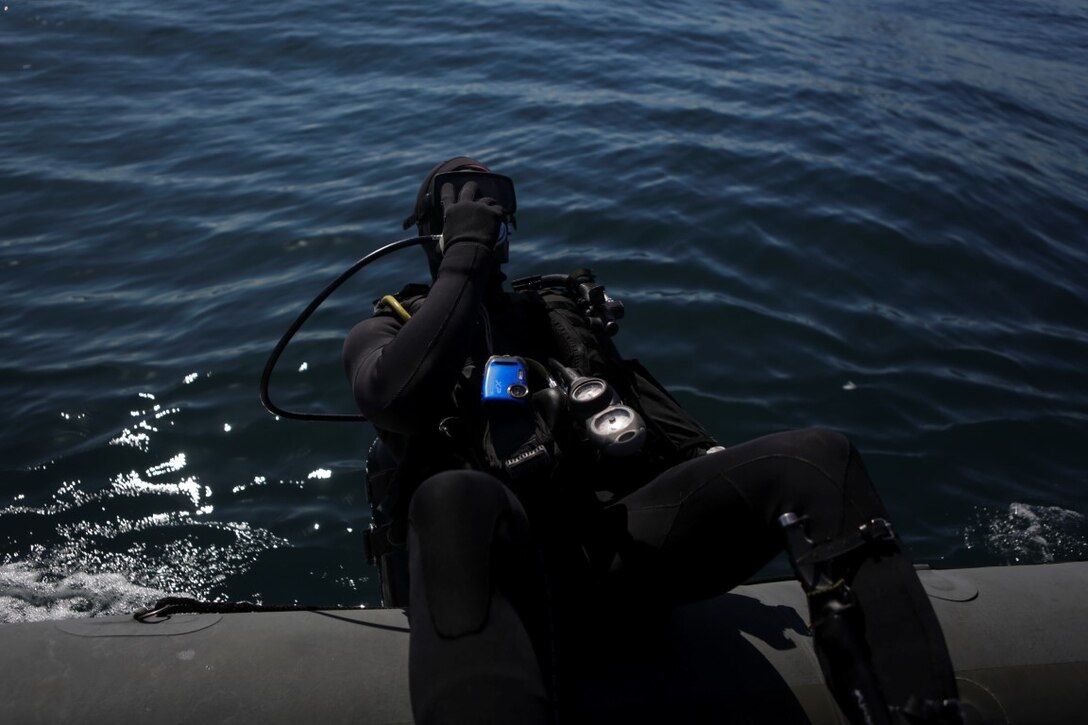 Captain Scott Williams, company commander of Company A, 1st Reconnaissance Battalion, 1st Marine Division, dives out of a rigid-hulled inflatable boat to conduct underwater search operations training, Jan. 28, 2016. The Marines and Sailors of Co. A will use their dive ability to give the 11th Marine Expeditionary Unit a valuable underwater search tool when it deploys later this year.