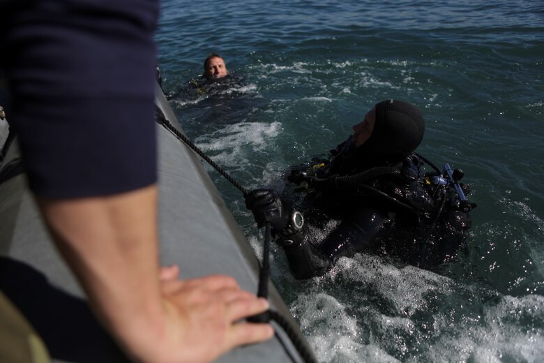 Marines with Company A, 1st Reconnaissance Battalion, 1st Marine Division, surface and prepare to board a rigid-hulled inflatable boat after conducting underwater search operations training, Jan. 28, 2016. The Marines and Sailors will use their dive ability to give the 11th Marine Expeditionary Unit a valuable underwater search tool when it deploys later this year.