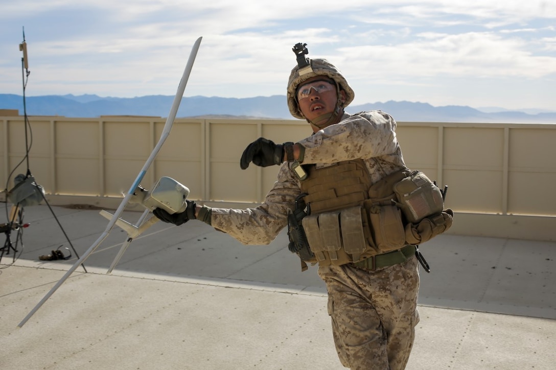 U.S. Marine Corps Gunnery Sgt. Leonel Cuellar, company 1st Sgt. with Lima Company, 3rd Battalion, 3rd Marine Regiment, 3rd Marine Division, throws a Raven drone for flight during urban defensive training during Integrated Training Exercise 2-16 at Marine Corps Air Ground Combat Center Twentynine Palms, Calif., Jan. 29, 2016. The training was conducted to strengthen unit coordination and maneuvers during urban terrain assaults. (U.S. Marine Corps photo by Cpl. Trever A. Statz/Released)
