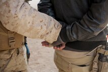 U.S. Marines with 3rd Battalion, 3rd Marine Regiment, 3rd Marine Division, detain residents during urban defensive training during Integrated Training Exercise 2-16 at Marine Corps Air Ground Combat Center Twentynine Palms, Calif., Jan. 29, 2016. The training was conducted to strengthen unit coordination and maneuvers during urban terrain assaults. (U.S. Marine Corps photo by Cpl. Trever A. Statz/Released)