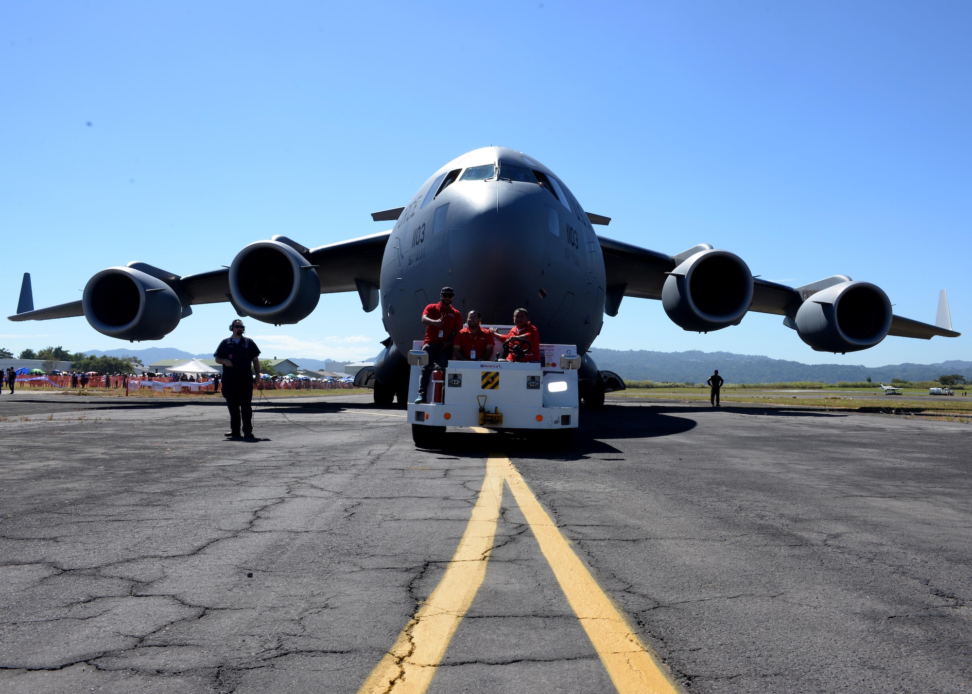 Ilopango International Airport workers, tow a U.S. Air Force C-17 Globemaster III cargo aircraft, 58th Airlift Squadron, on a runway at San Salvador, El Savador, Jan. 30, during the 2016 Ilopango Airshow. The C-17 was sent from Altus Air Force Base, Okla., to foster relationships between the U.S. and El Salvador. The aircraft was setup as a static display for the attendees to view and learn about some of its capabilities. (U.S. Air Force photo by Senior Airman Franklin R. Ramos/Released)