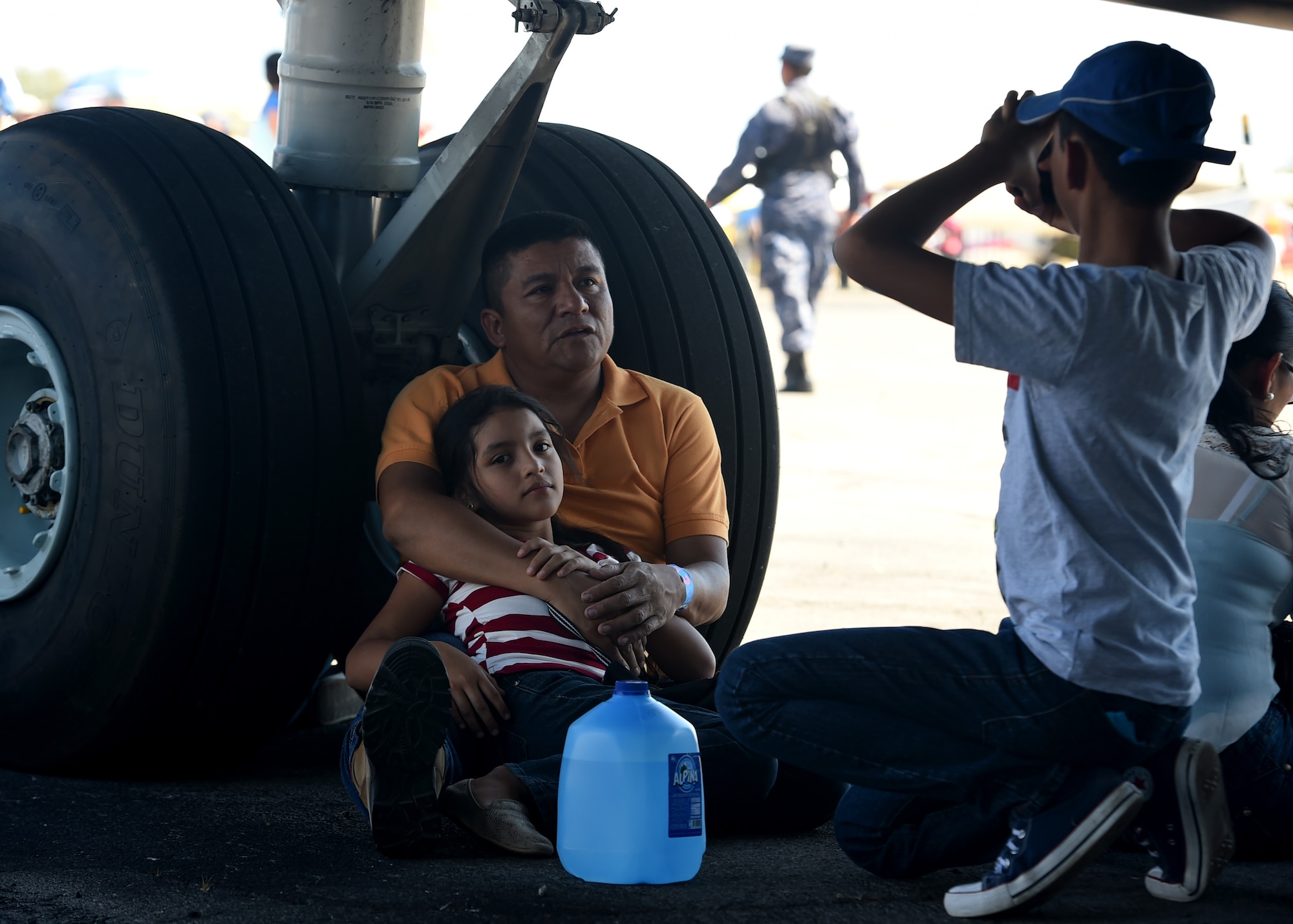 Citizens from El Salvador sit under a U.S. Air Force C-17 Globemaster III cargo aircraft, 58th Airlift Squadron, at Ilopango International Airport in San Salvador, El Savador, Jan. 30, during the 2016 Ilopango Airshow. The C-17 was sent from Altus Air Force Base, Okla., to foster relationships between the U.S. and El Salvador. The aircraft was setup as a static display for the attendees to view and learn about some of its capabilities. (U.S. Air Force photo by Senior Airman Franklin R. Ramos/Released)