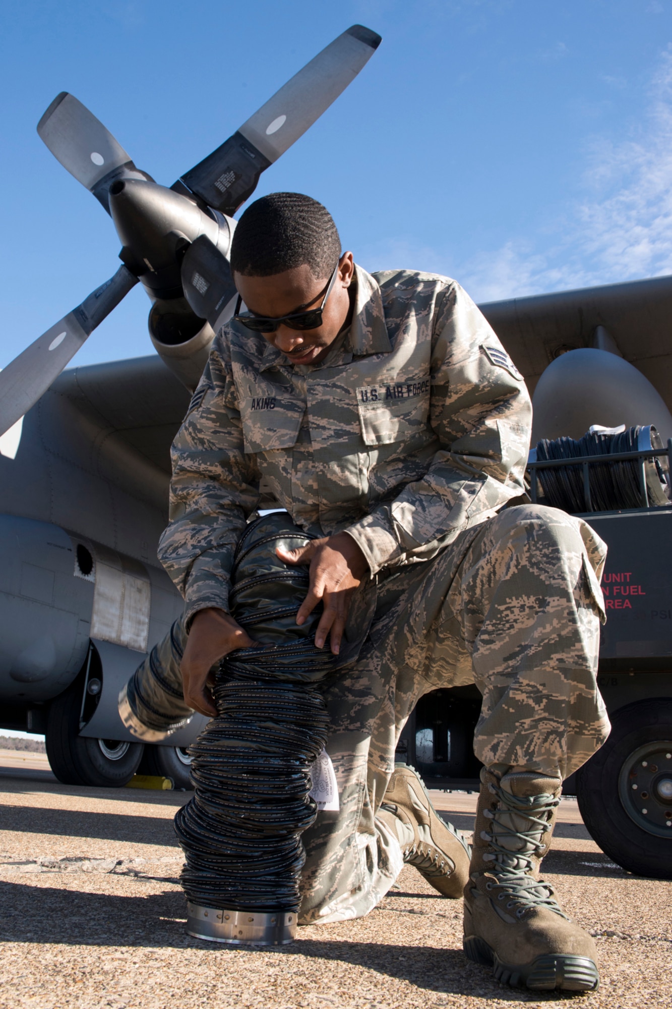 U.S. Air Force Reserve Senior Airman Kquamae Akins, a crew chief assigned to the 913th Maintenance Squadron, compresses a heater hose for storage at Little Rock Air Force Base, Ark., Jan. 28, 2016. Akins was one of six Airmen assigned to the 913 MXS, who were given the opportunity to ride on the final training mission flight of a C-130H for the 913th Airlift Group at Little Rock AFB. (U.S. Air Force photo by Master Sgt. Jeff Walston/Released)