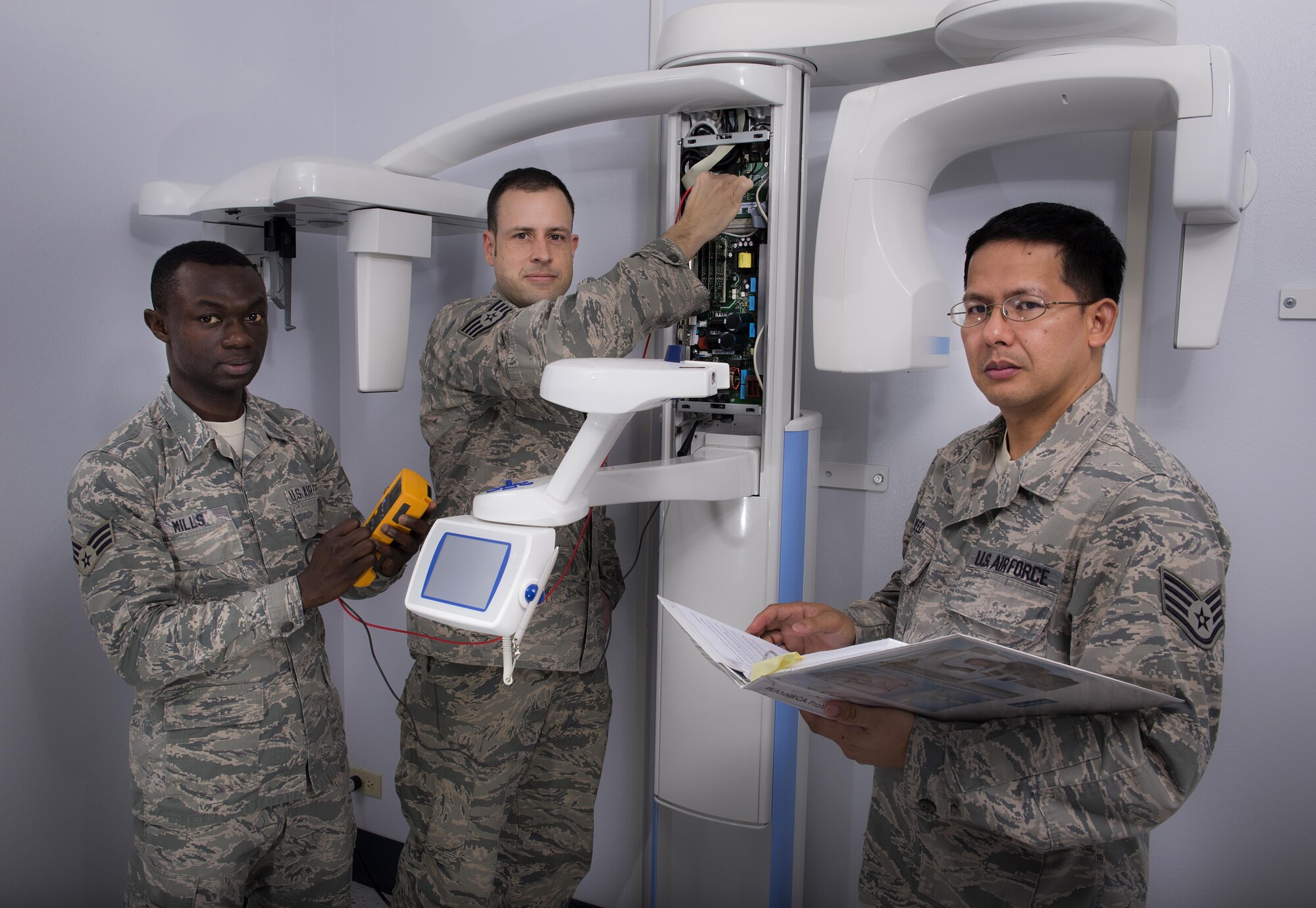 Senior Airman Bright Mills (left), Staff Sgt. Joshua Meyer (middle), and Staff Sgt. Gerry Reed (right), are a three-member biomedical equipment repair team who fixed a $103,000 x-ray machine at Sheppard Air Force Base, Texas. This team spent more than 50 hours getting the machine back on line. (U.S. Air Force photo/Senior Airman Kyle Gese)