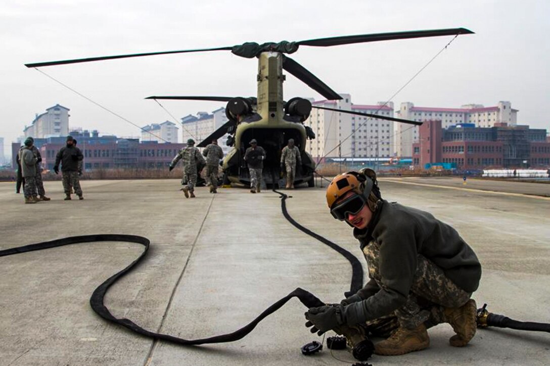 A soldier connects fuel lines during a forward arming and refueling point contest at U.S. Army Garrison Humphreys in South Korea, Jan. 28, 2016. The soldier is assigned to the 2nd Infantry Division's 2nd Combat Aviation Brigade. Army photo by Pfc.Yeo Yun Hyeok