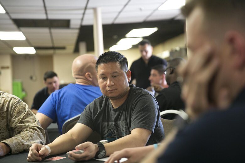 John Flores, client services representative, Supplycore, deals a hand of cards during the Hashmarks Staff Non-Commissioned Officer Club Texas Hold’em Poker Tournament, Jan. 30, 2016. The winner received a base exchange gift card comprised of the money made through entry fees and the purchase of poker chips. (Official Marine Corps photo by Cpl. Thomas Mudd/Released)
