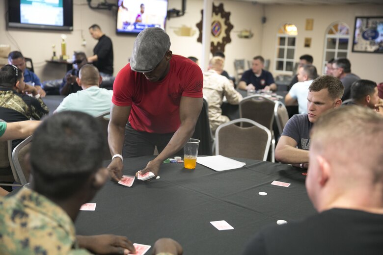 Sgt. Maj. Brain Priester, sergeant major, 1st Tank Battalion, deals a hand of cards during the Hashmarks Staff Non-Commissioned Officer Club Texas Hold’em Poker Tournament, Jan. 30, 2016. (Official Marine Corps photo by Cpl. Thomas Mudd/Released)