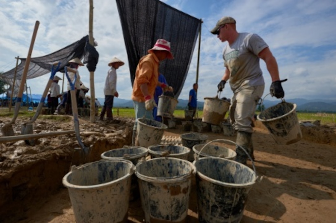 U.S. Marine Sgt. Daniel Sutfin, Defense PIOW/MIA Accounting Agency (DPAA) augmentee, moves buckets with local workers at an excavation site in Dien Bien province, Vietnam, Nov. 23, 2015. Sutfin, a military policeman deployed from Camp Hansen, Okinawa, Japan, is part of a DPAA recovery team searching for two crew members lost in an F-4C aircraft crash during the Vietnam War. The DPAA mission is to provide the fullest possible accounting for our missing personnel to their families and the nation. (DoD photo by Staff Sgt. Kathrine Dodd, USAF/RELEASED)
