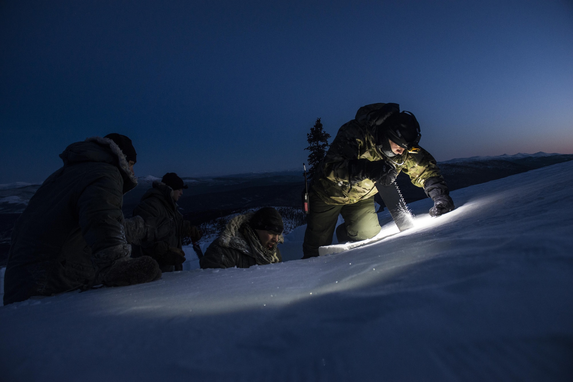Students cut snow blocks during Survival Evasion Resistance Escape (S.E.R.E) 5-level training Jan 21, 2016, in the Joint Pacific Alaska Range Complex. The Arctic survival training is a weeklong course that gives the S.E.R.E. specialist hands on experience with building shelters and surviving the extreme temperatures of the arctic. (U.S. Air Force photo by Staff Sgt. Joshua Turner/Released)