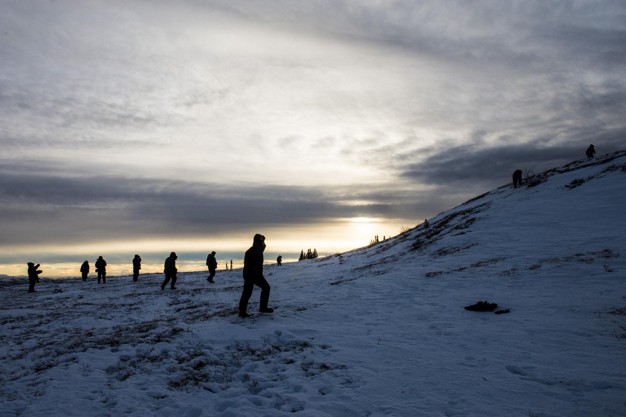 Students walk around to keep warm during Survival Evasion Resistance Escape (S.E.R.E) 5-level training Jan 22, 2016, in the Joint Pacific Alaska Range Complex. The Arctic survival training is a weeklong course that gives the S.E.R.E. specialist hands on experience with building shelters and surviving the extreme temperatures of the arctic. (U.S. Air Force photo by Staff Sgt. Joshua Turner/Released)