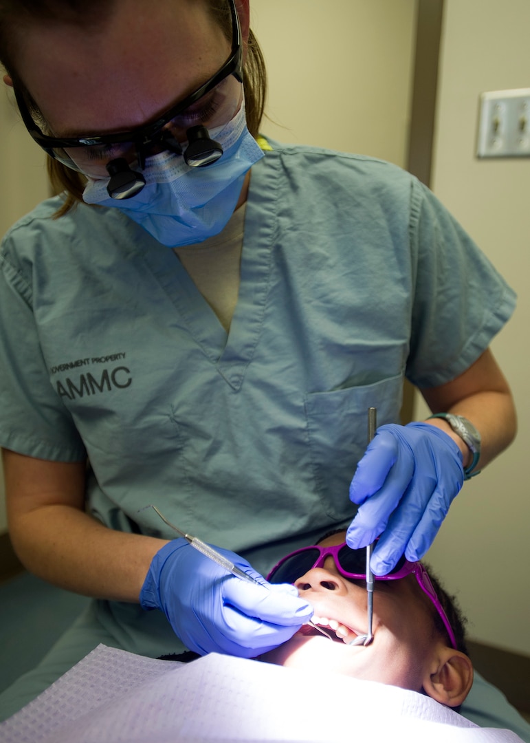 Capt. Christina Wengler, 59th Dental Training Group pediatric dentist, examines a 6-year-old's teeth Jan. 20 at Dunn Dental Clinic, Joint Base San Antonio-Lackland, Texas. Regular dental check-ups, good oral hygiene habits and healthy eating and drinking habits help children prevent tooth decay and gum diseases. (U.S. Air Force photo/Staff Sgt. Kevin Iinuma)