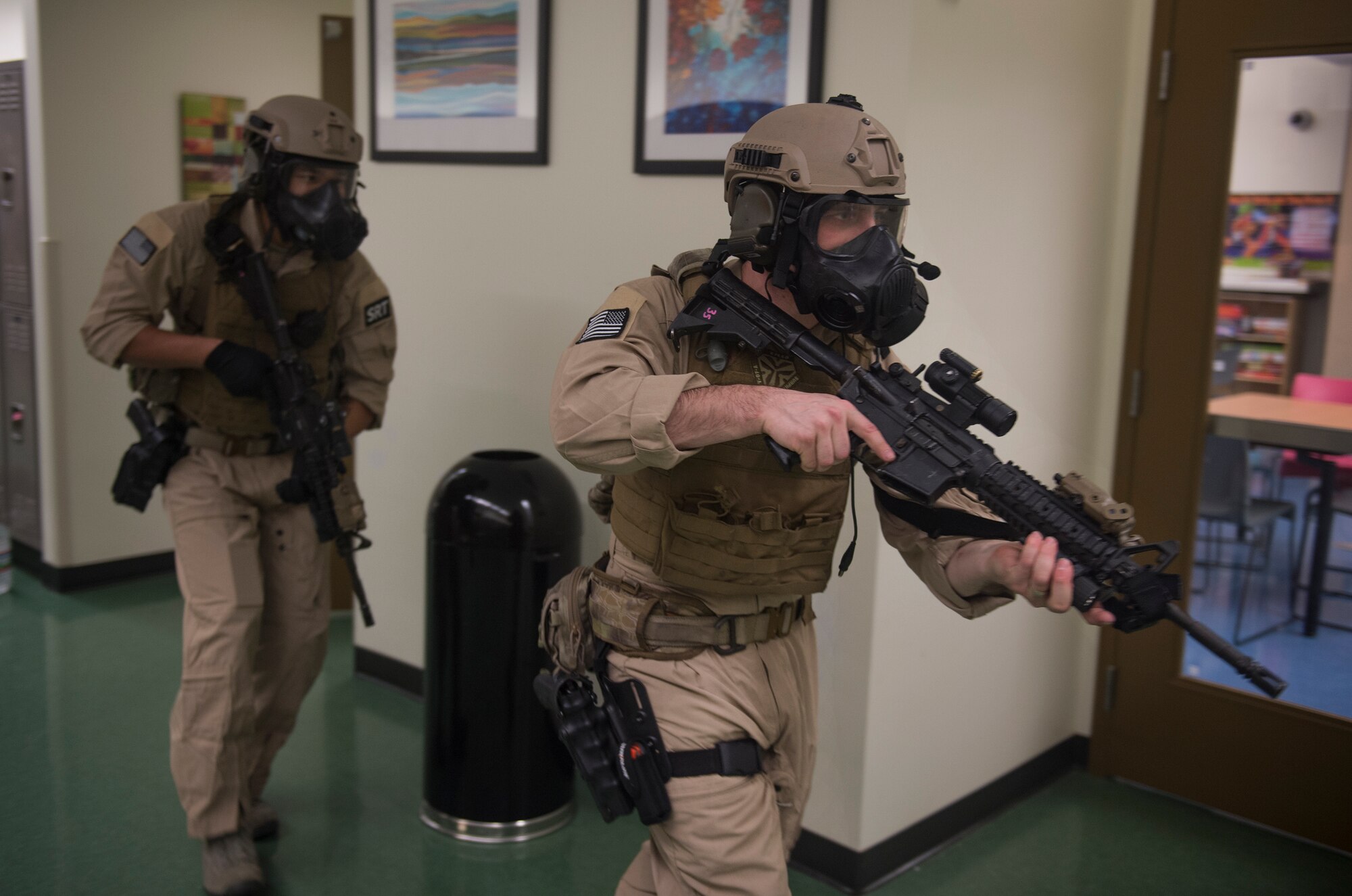 U.S. Air Force Senior Airman Randal Williams, 23d Security Forces Squadron flight armorer, left, and Staff Sgt. Matthew Roush, 23d SFS combat arms training and maintenance instructor, clear a hallway during SRT training at the youth center, Jan. 28, 2016, at Moody Air Force Base, Ga. The SRT also trains with local law enforcement to become familiar with their procedures and to share techniques. (U.S. Air Force photo by Tech. Sgt. Zachary Wolf/Released)