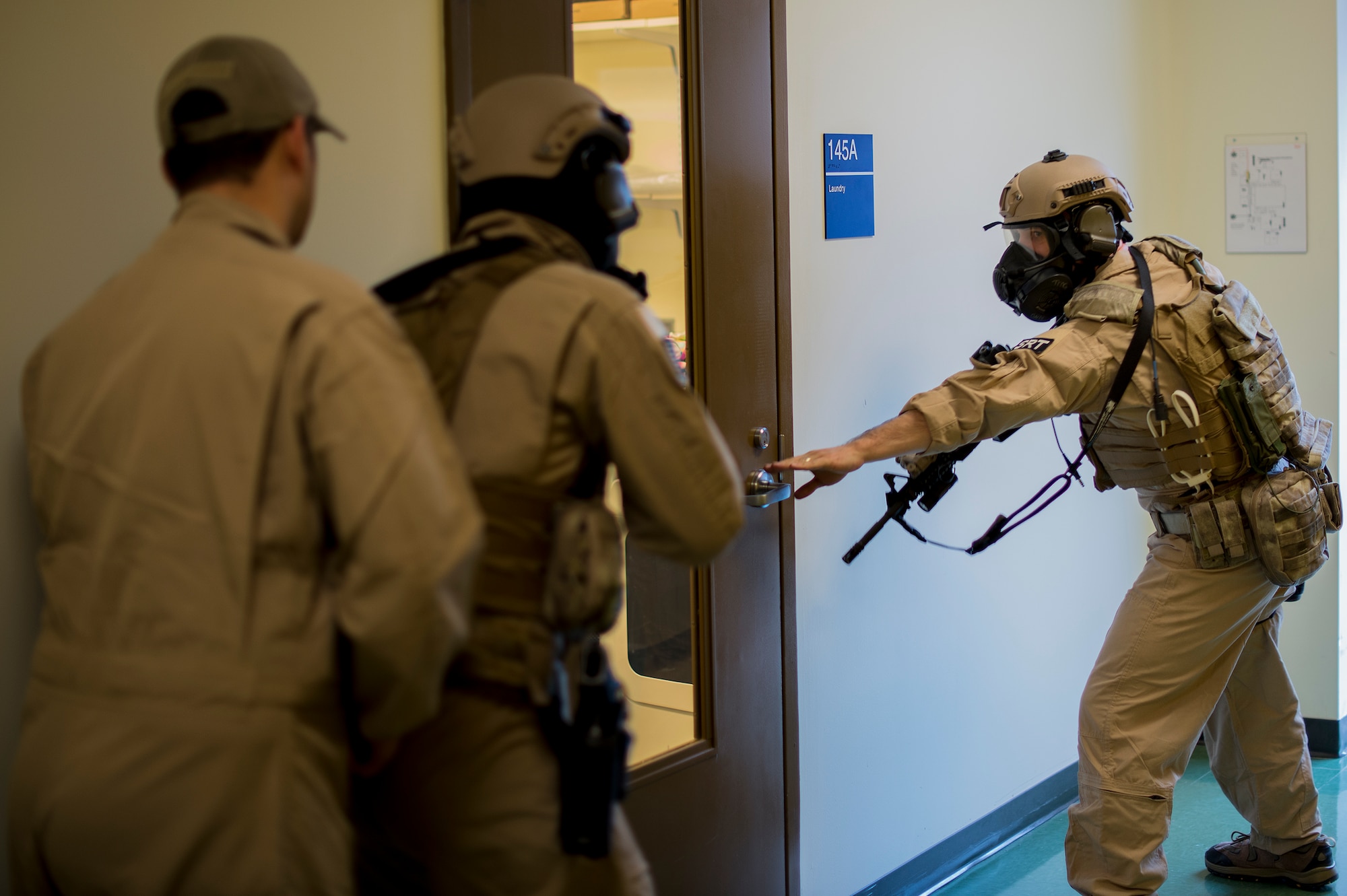 U.S. Air Force Staff Sgt. Matthew Roush, 23d Security Forces Squadron combat arms training and maintenance instructor, prepares to open a door for his teammates at the youth center, Jan. 28, 2016, at Moody Air Force Base, Ga. The SRT practiced clearing procedures in order to train for real-world scenarios and the potential for hostile situations. (U.S. Air Force photo by Tech. Sgt. Zachary Wolf/Released)