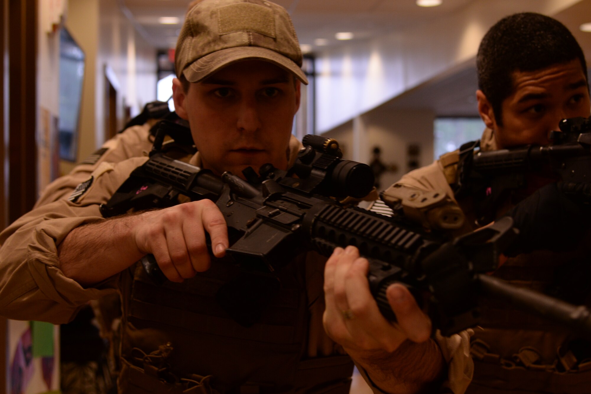 U.S. Air Force Staff Sgt. Matthew Roush, 23d Security Forces Squadron combat arms training and maintenance instructor, left, and Senior Airman Randal Williams, 23d SFS flight armorer clear a hallway during Special Reaction Team training, Jan. 28, 2016, at Moody Air Force Base, Ga. The SRT uses teamwork and specialized communication techniques to keep track of one another without giving up their position. (U.S. Air Force photo by Airman 1st Class Janiqua P. Robinson/Released)