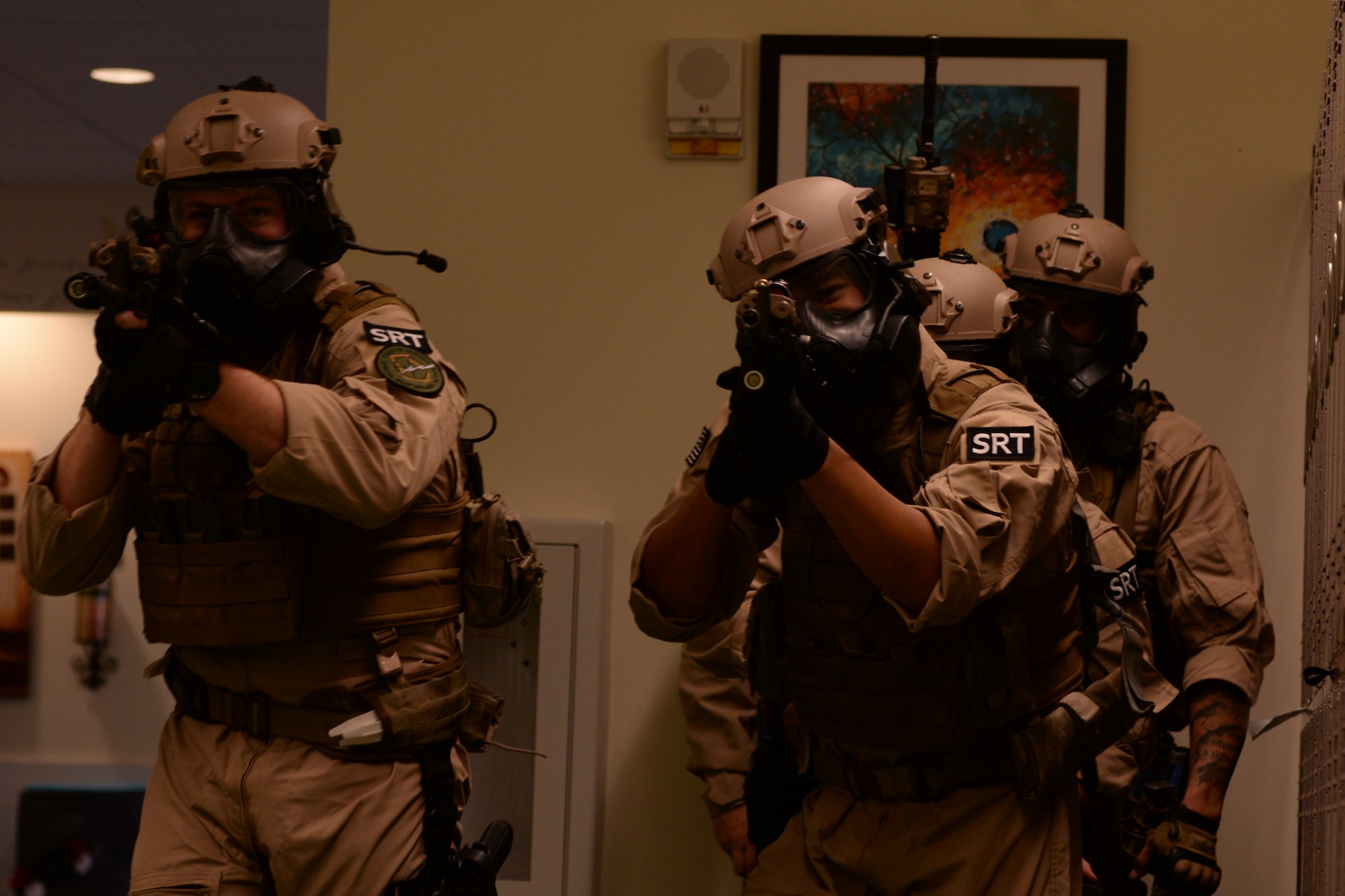 U.S. Air Force Staff Sgt. Andrew Morris, 23d Security Forces Squadron NCO in charge of combat arms, left, Senior Airman Randal Williams, 23d SFS flight armorer, middle, and Staff Sgt. Israel Garza, 23d SFS unit trainer, prepare to clear and secure a hallway during a Special Reaction Team training, Jan. 28, 2016, at Moody Air Force Base, Ga. The SRT practiced clearing rooms and used teamwork to enhance mission capabilities. (U.S. Air Force photo by Airman 1st Class Janiqua P. Robinson/Released)