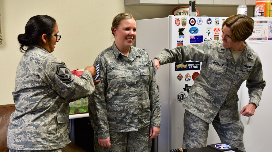 Newly promoted Tech. Sgt. Amanda Schemmel, chief of installation personnel readiness in the 932nd Force Support Squadron has her new stripes pinned on by 1st Lt. Liz Wszalek and Senior Master Sgt. Terri Ray, both with the FSS, Dec. 30, 2015, Scott Air Force Base, Illinois.  Schemmel knew about the promotion but was surprised with her pin on ceremony while attending another event.  It was even a bigger surprise to have Wszalek there to help pin on the stripes.  (U.S. Air Force photo by Christopher Parr)