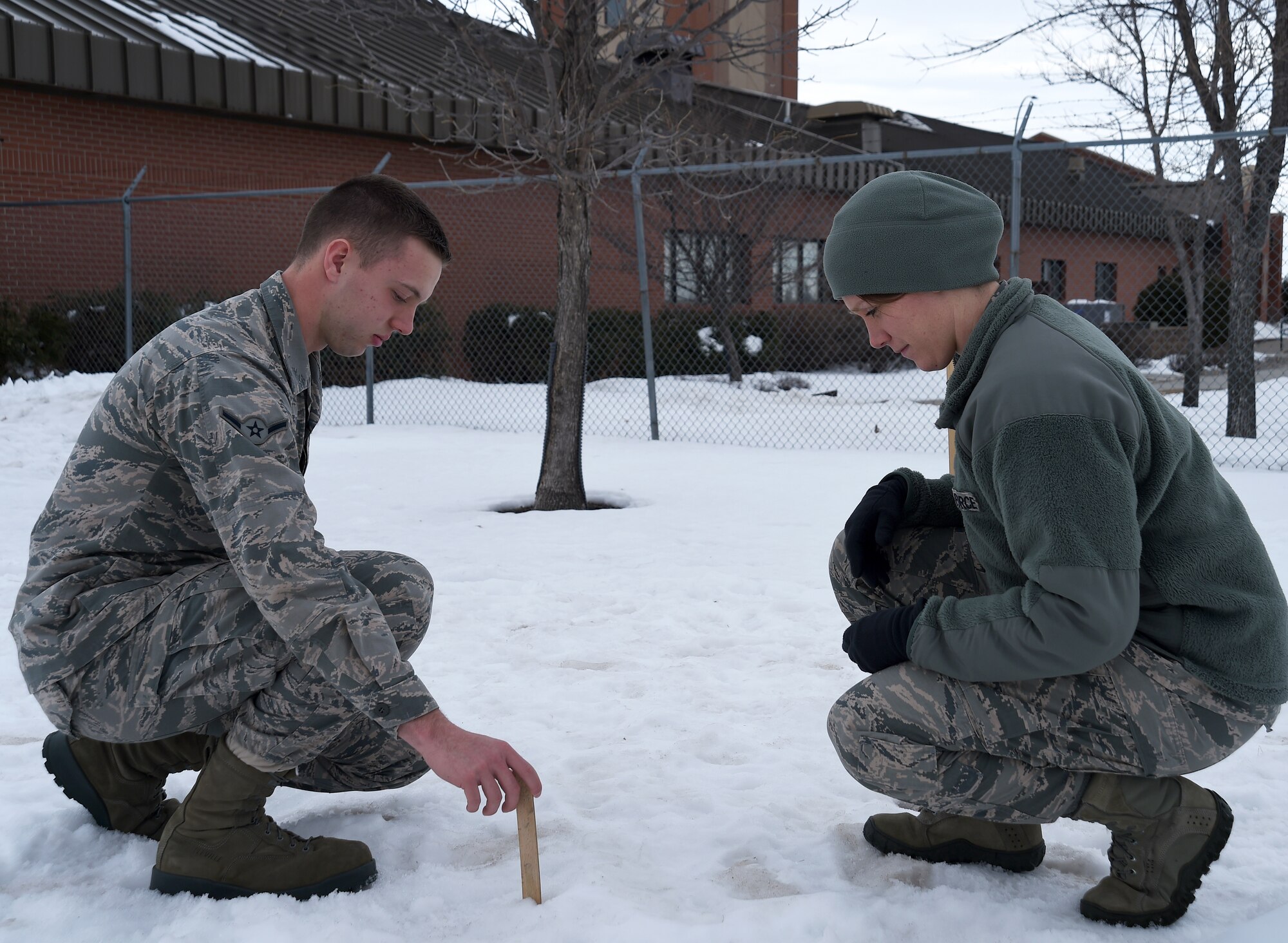 Airman Jackson Calloway and Staff Sgt. Anna Harris, 319th Operations Support Squadron Weather Flight weather forecasters, measure the snow on Grand Forks Air Force Base, North Dakota, Jan. 29, 2016. Grand Forks receives an average of 40 inches of snow each winter, but the expected amount for this winter is 25 inches. (U.S. Air Force photo by Senior Airman Bonnie Grantham/released)