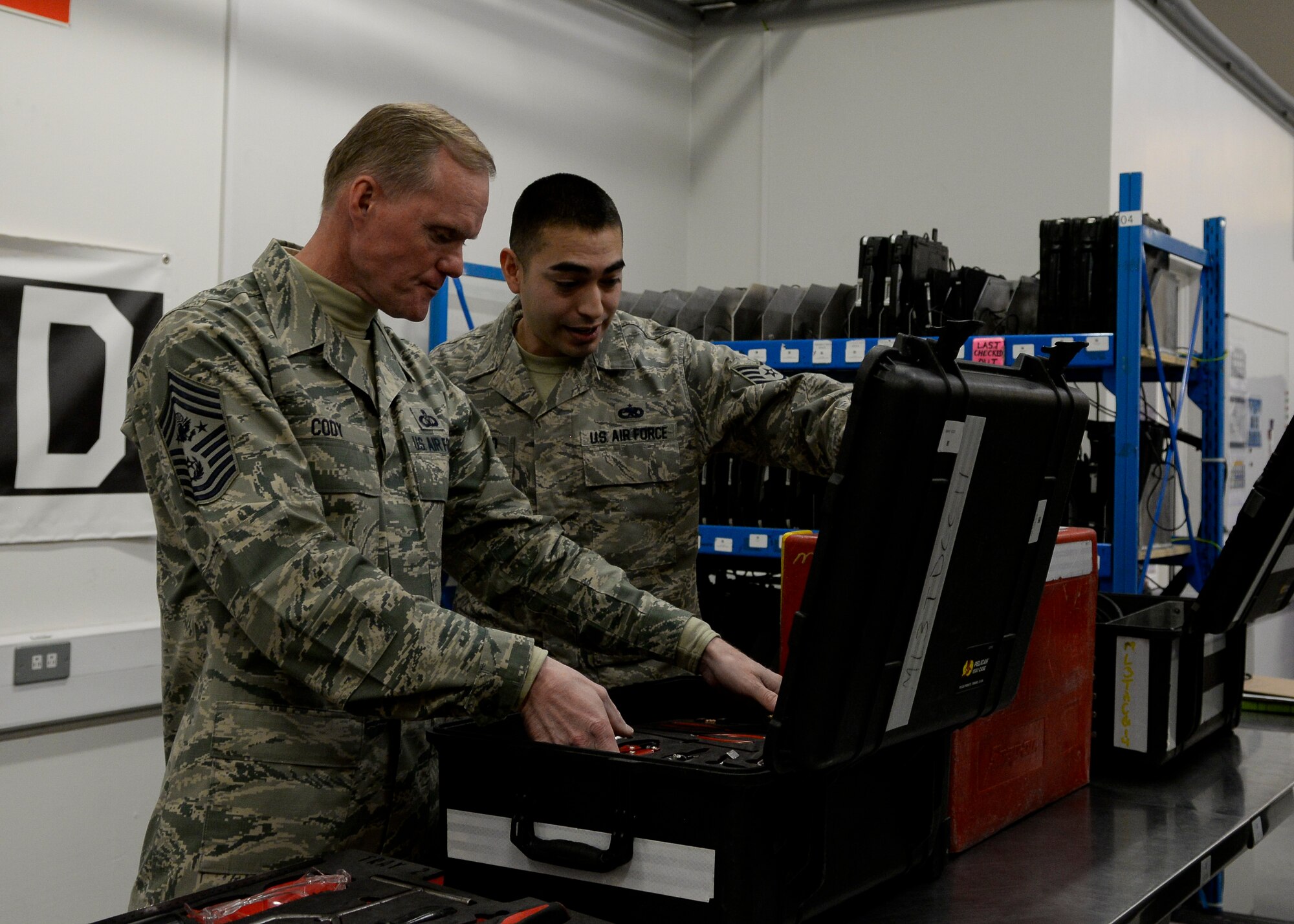 U.S. Air Force Staff Sgt. Nickalos Alvarado, 100th Aircraft Maintenance Squadron dedicated crew chief, shows Chief Master Sgt. of the Air Force James Cody a tool kit Jan. 28, 2016, on RAF Mildenhall, England. Cody met with Airmen from multiple units during his visit including the 352nd Special Operations Wing, the 95th Reconnaissance Squadron and the 488th Intelligence Squadron. (U.S. Air Force photo by Senior Airman Victoria H. Taylor/Released)