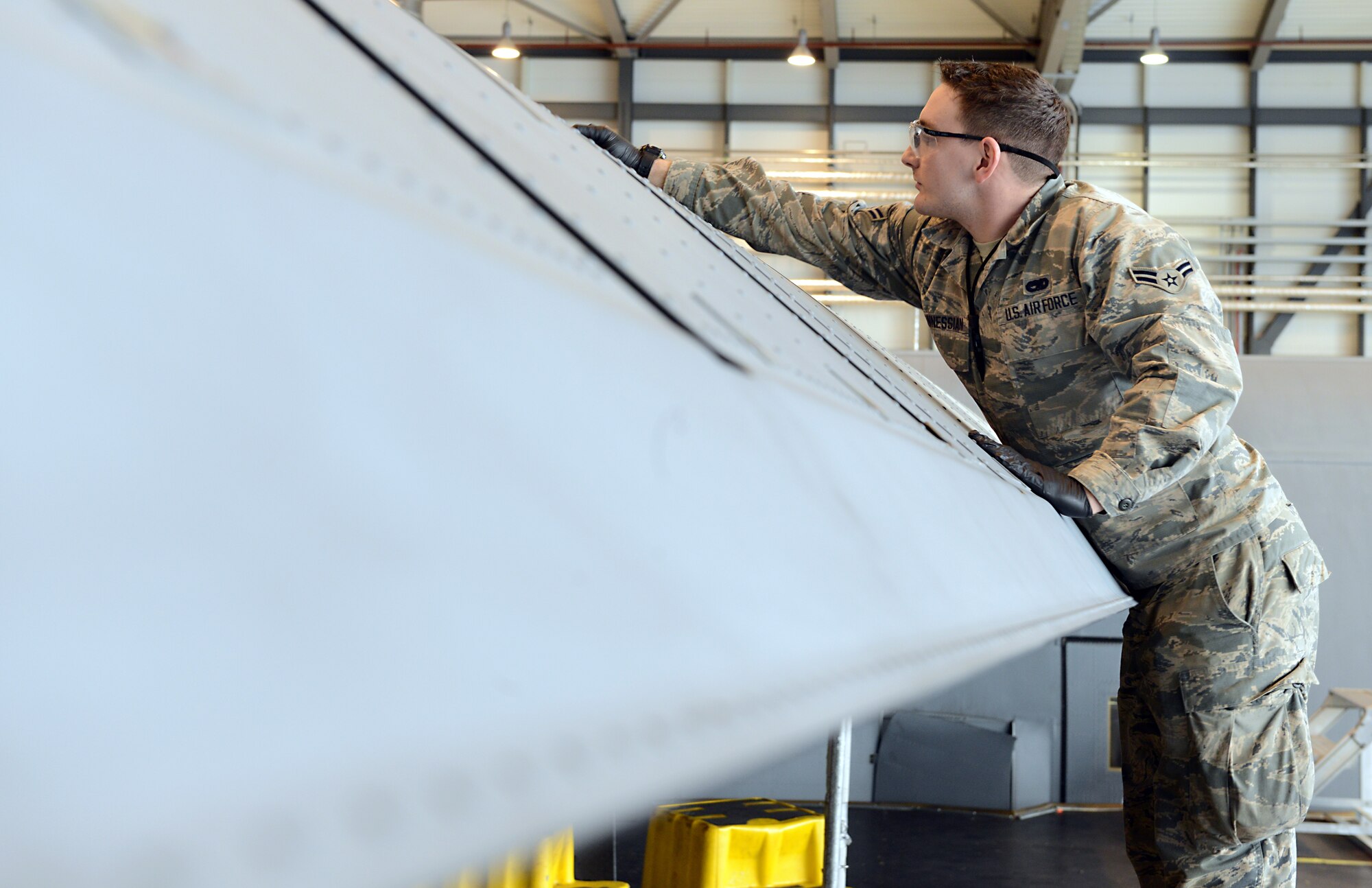 Airman 1st Class Zachary Ohannessian, 86th Maintenance Squadron crew chief, wipes  lubricant off the wings of a C-130J Super Hercules Jan. 13, 2016, at Ramstein Air Base, Germany. As the lubricant is applied to the bearings below the wing, it sometimes leaks onto the top. (U.S. Air Force photo/Staff Sgt. Timothy Moore)