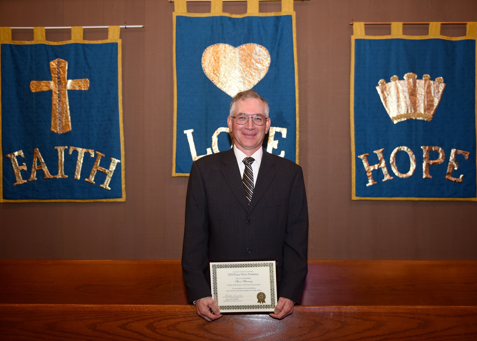 Steven Heuring, 30th Space Wing Public Affairs visual information specialist, was recognized for his nomination of the sixth Valley of the Flowers Peace Prize Award, Jan. 31, 2016, Lompoc, Calif. The Peace Prize was commissioned by the Valley of the Flowers Church of Christ in 2010, to honor individuals who further peace and reconciliation in Lompoc. Heuring was one of 10 nominees honored at the award ceremony Sunday, for his dedication to his community. As the president of the Vandenberg Village Association and a civilian employee at Vandenberg Air Force Base, he has participated in community projects that have led to better communication and understanding among residents. In August 2015, he organized a public panel discussion attended by various county agencies. By bringing these agencies together, a better understanding for the concerns of the community was reached. Additionally, Heuring spearheaded the 30th SW “Computers for Learning” program. His participation in this initiative has given local schools government computer equipment, providing computer access for teachers and children in the community. (U.S. Air Force photo by Senior Airman Kyla Gifford/Released) 