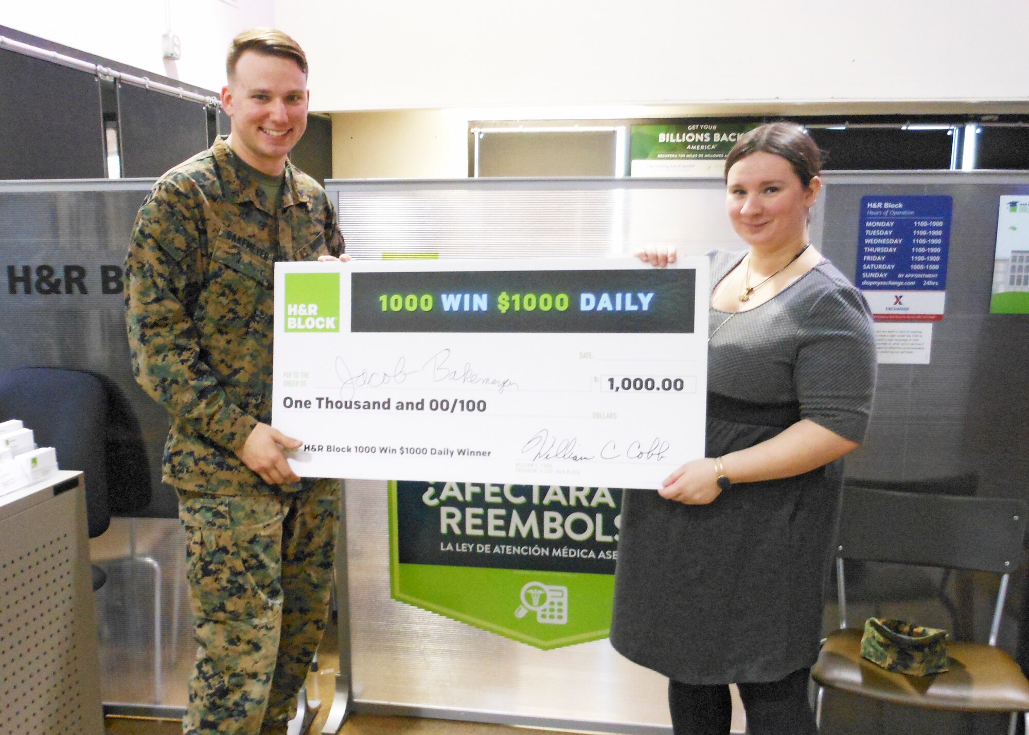 Lance Cpl. Jacob Bakemeyer, VMX-22, is presented a check worth $1,000 by H&R Block employee Amy Plieth. Bakemeyer was automatically entered for a chance to win when he scheduled an appointment with the Edwards H&R Block location in the Edwards Exchange. (Courtesy photo)

