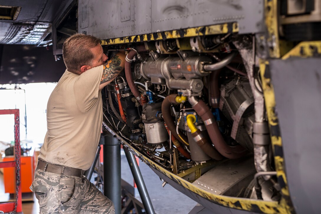 Tech. Sgt. Terry Harrower of the 189th Airlift Wing buries his arms deep inside a C-130 H engine.