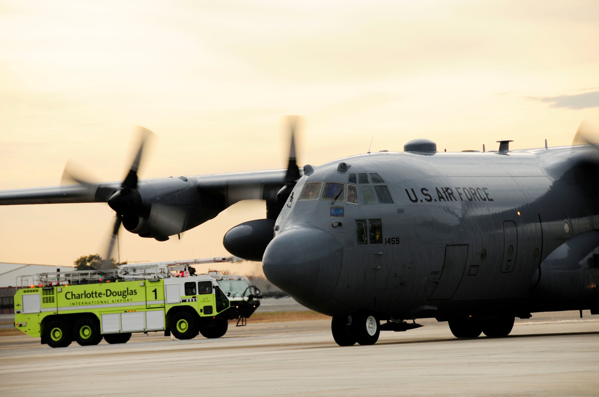 U.S. Air Force Col. Quincy Huneycutt, III, Vice Wing commander and navigator for the 145th Airlift Wing, along with his brother, loadmaster, Chief Master Sgt. Andrew Huneycutt, proceed  through an arc of water sprayed from two fire trucks after landing at the North Carolina Air National Guard Base, Charlotte Douglas International Airport; December 21, 2015. Dowsing the aircraft is part of a longstanding military tradition; honoring aviators with a symbolic salute as they complete their final flight before retirement. Combined, the brothers leave the 145th Airlift Wing with over 72 years of honorable military service. (U.S. Air National Guard photo by Master Sgt. Patricia F. Moran/Released)