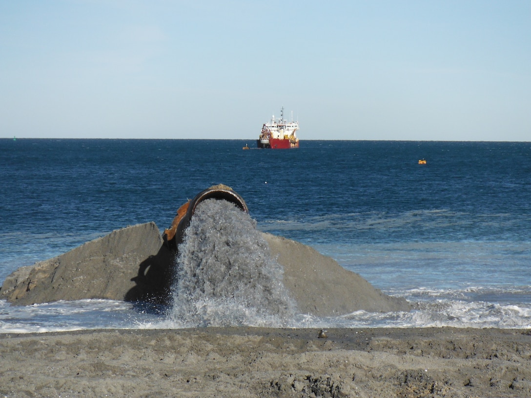 As the hydraulic dredge operates in the distance, clean sand is deposited onto Town Neck Beach in Sandwich, Massachusetts.
