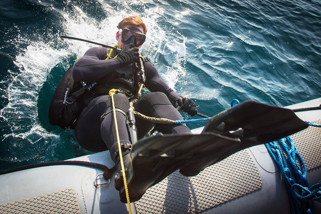 Navy Petty Officer 2nd Class Matthew Krom enters the Arabian Gulf to locate a training mine during a mine countermeasures exercise, Jan. 25, 2016. Krom is assigned to Commander, Task Group 56.1. Navy photo by Petty Officer 2nd Class Torrey W. Lee