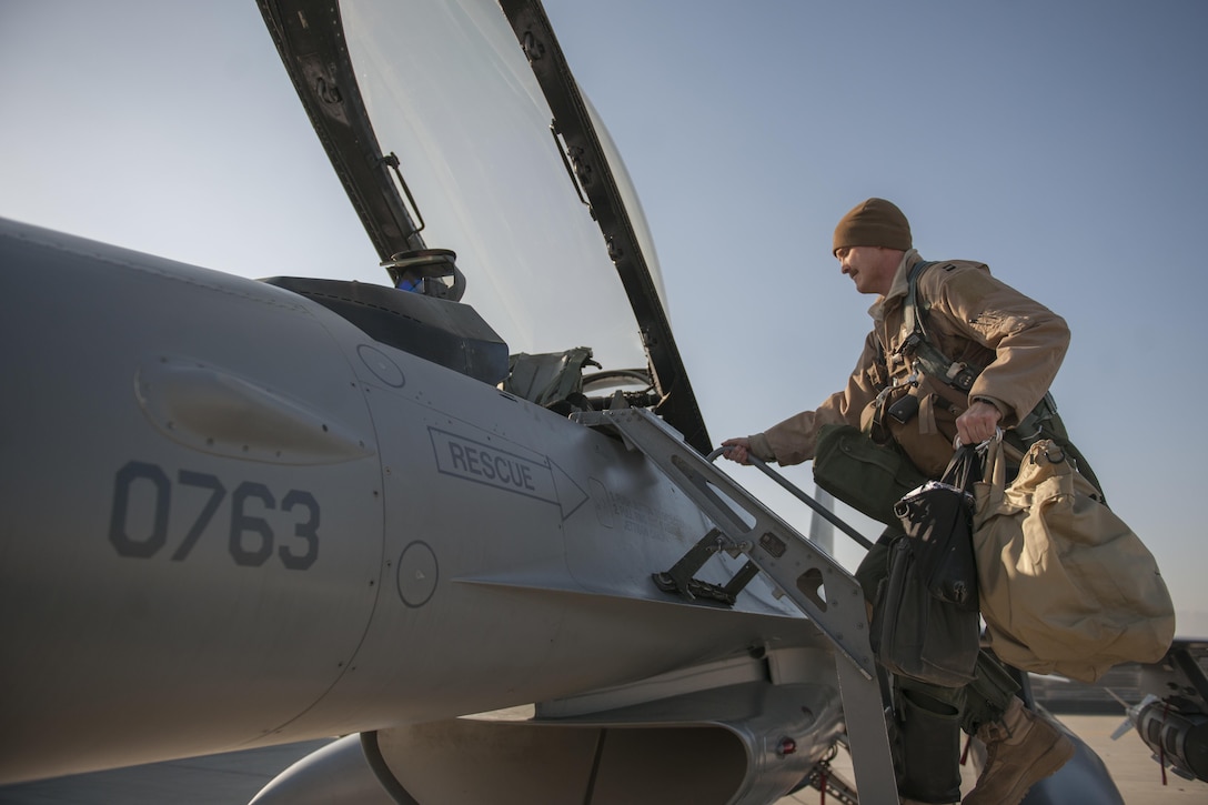 Air Force Capt. Brad Hunt climbs up to the cockpit of an F-16 Fighting Falcon aircraft carrying two guided bomb units on Bagram Airfield, Afghanistan, Feb. 1, 2016. Hunt is a pilot assigned to the 421st Expeditionary Fighter Squadron. Air Force photo by Tech. Sgt. Robert Cloys