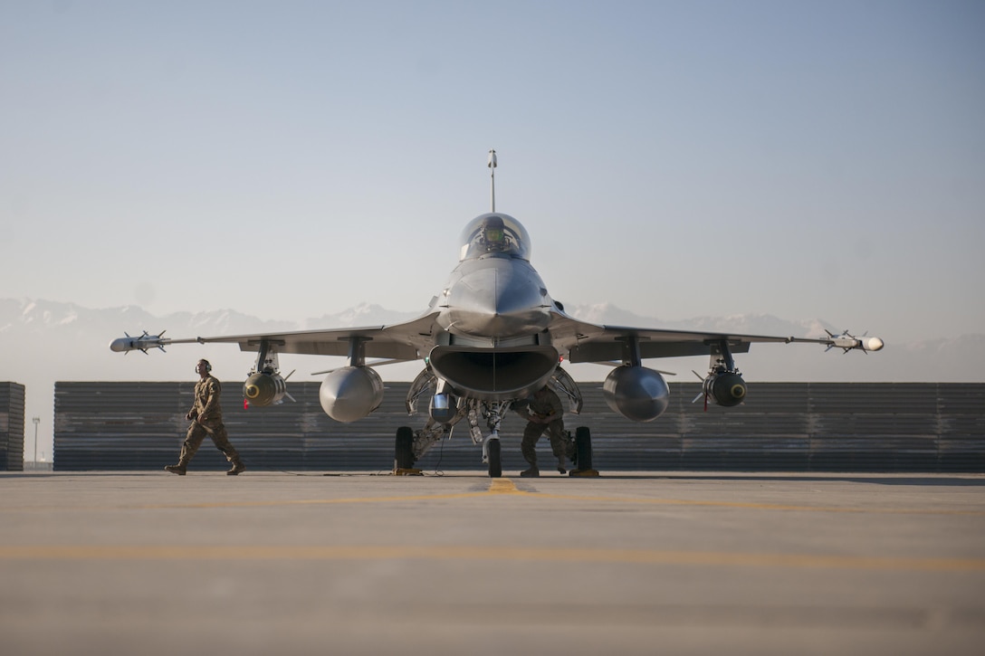 Air Force maintainers finish inspecting the outside of an F-16 Fighting Falcon aircraft while Air Force Capt. Brad Hunt performs preflight checks inside the cockpit on Bagram Airfield, Afghanistan, Feb. 1, 2016. Hunt is a pilot assigned to the 421st Expeditionary Fighter Squadron. Air Force photo by Tech. Sgt. Robert Cloys