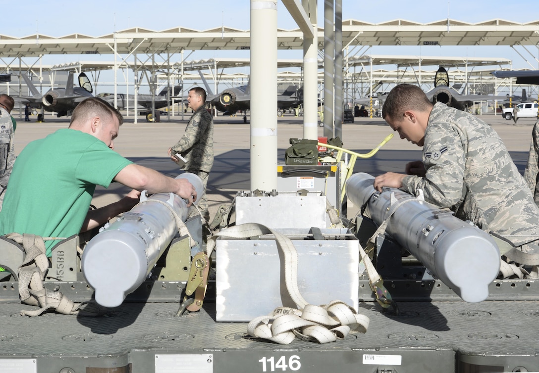Load crew members from opposing teams race to prepare munitions for loading Jan. 29 during the 2015 Annual Load Crew Competition at Luke Air Force Base. Six load crew teams, including two from Holloman AFB, New Mexico, competed. The winner will be announced at the Maintenance Professional of the Year Banquet in March. 