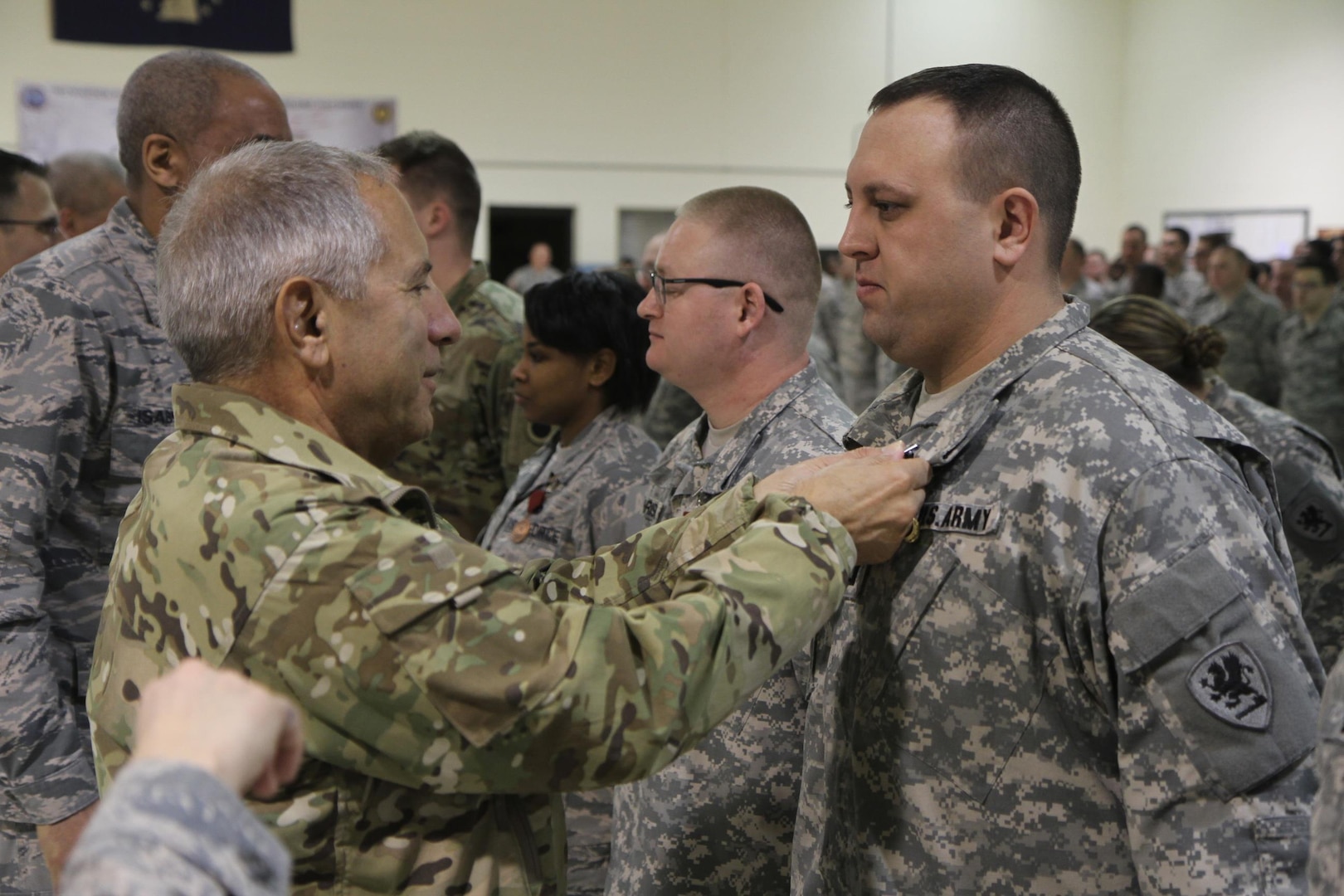 Maj. Gen. Gregory Vadnais, adjutant general of the Michigan National Guard, awards Capt. Anthony Corsi, a member of the Detroit-based 1225th Support Battalion, with a Michigan Active State Service Ribbon with Bronze Oak Leaf Device and the Michigan Legion of Merit Medal, Jan. 25, 2016, for his service with Task Force Flint. Corsi and four other Michigan National Guard Soldiers comprised the TFF Warehouse team that managed the inventory of bottled water and other supplies distributed to Flint residents. 