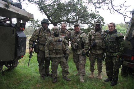 Danish army Soldiers stand next to U.S. Army Staff Sgt. Mark Korte, center, a civil affairs noncommissioned officer with Company B, 457th Civil Affairs Battalion, 361st Civil Affairs Brigade, 7th CSC and a native of El Cerrito, Calif., and U.S. Army Sgt. 1st Class Jerome Smith, a civil affairs NCO with Company B, 457th CA Battalion, 361st CA Brigade, 7th CSC and a native of Tampa, Fla., June 18, 2015 and their Danish interpreter during the Danish army’s Civil Military Cooperation Support Team, 2nd Armored Infantry Battalion’s NATO Response Force validation and training exercise Brave Lion 15, held June 8-19, 2015. (Photo by Sgt. 1st Class Matthew Chlosta, 7th CSC Public Affairs Office)