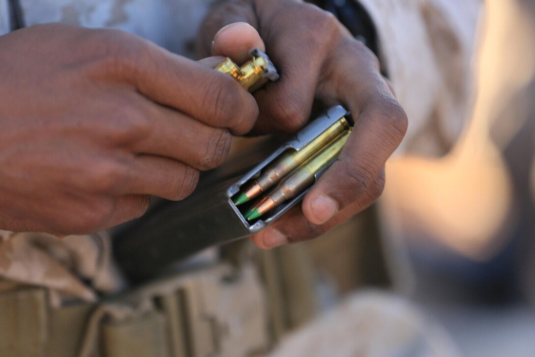Corporal Robert Ellis, rifleman, 3rd Battalion, 4th Marines, 7th Marine Regiment, loads an M27 Infantry Automatic Rifle magazine with 5.56 mm rounds during the Designated Marksman Course’s culminating event at Range 113, Jan. 28, 2016. (Official Marine Corps photo by Cpl. Julio McGraw/Released)