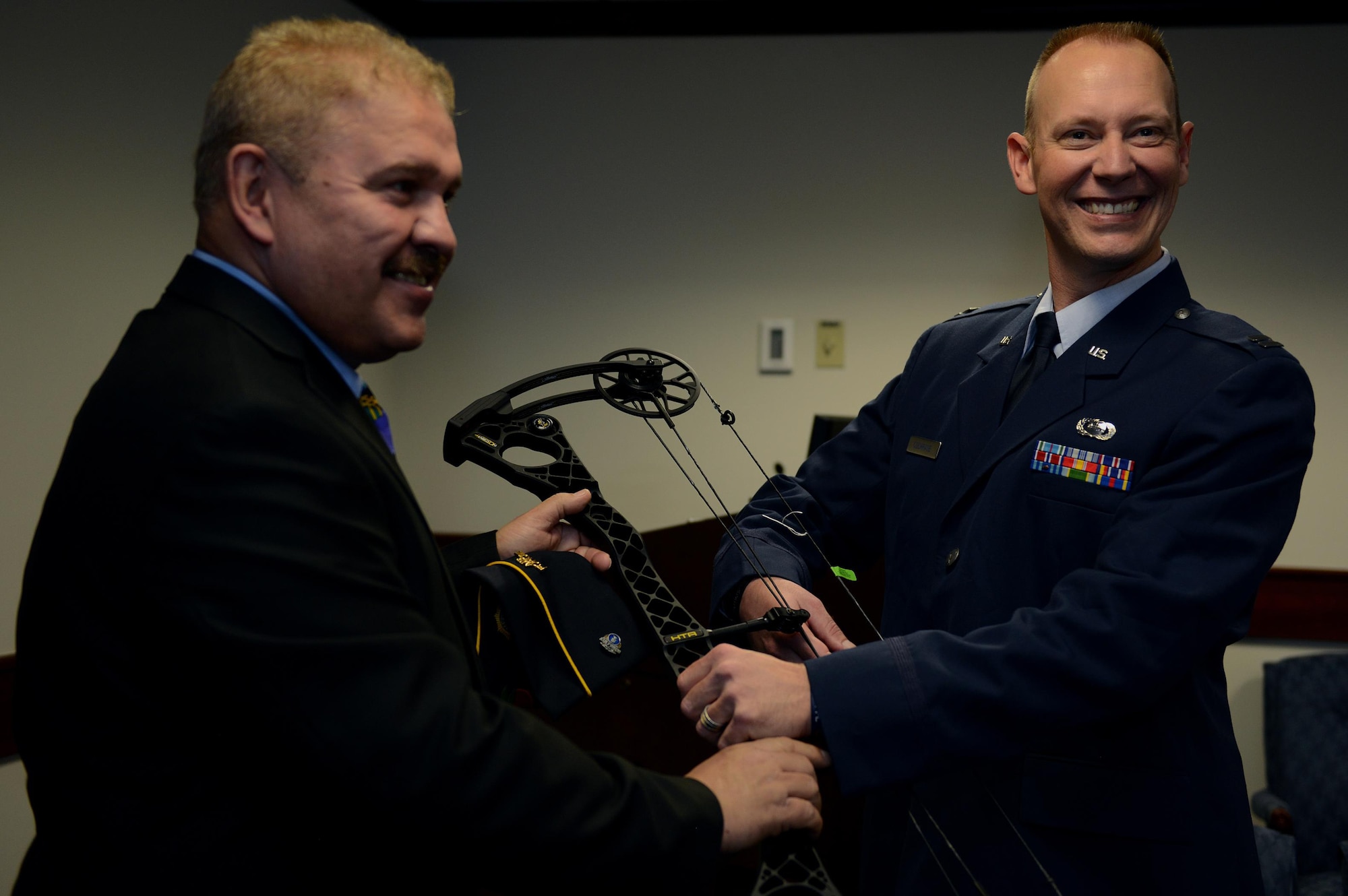 Albert Diaz, American Legion Florida Veterans Service Director, presents Capt. Chris Cochrane with an adaptive compound bow at Hurlburt Field, Fla., Jan 28, 2016. Cochrane, an Air Force Special Operations Command Wounded Warrior, suffered a stroke in 2013 that left him paralyzed on his right side. Cochrane, with his new bow, plans to participate in the upcoming Air Force Wounded Warrior trails at Nellis Air Force Base, Nev., in February. (U.S. Air Force photo/Chief Master Sgt. Quinton T. Burris) 