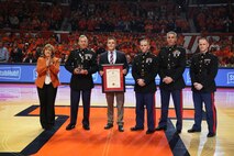 Jordan Meadows is presented the Commandant of the Marine Corps Trophy by members of Recruiting Station St. Louis Jan. 31 at the University of Illinois Basketball game for finishing top of his class of 220 Officer Candidates. Jordan's superb physical fitness, self-less leadership and successful academics distinguished him as the number one candidate.