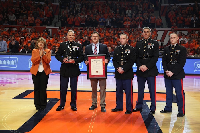 Jordan Meadows is presented the Commandant of the Marine Corps Trophy by members of Recruiting Station St. Louis Jan. 31 at the University of Illinois Basketball game for finishing top of his class of 220 Officer Candidates. Jordan's superb physical fitness, self-less leadership and successful academics distinguished him as the number one candidate.