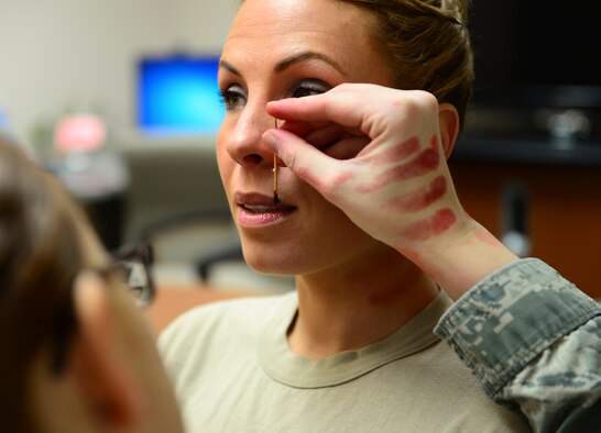 Tech. Sgt. Catherine Truesdell, 354th Operations Support Squadron noncommissioned officer in charge of Red Flag SARM operations, gets a split lip and choke marks applied to her face and neck Jan. 21, 2016, at Eielson Air Force Base, Alaska. Truesdell volunteered to help raise awareness for domestic violence through the “Thanks for Asking” campaign. (U.S. Air Force photo by Airman 1st Class Cassandra Whitman/Released)